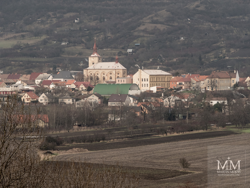 View of the village Trebenice below the mountain Kostalov, in the middle the church of the Nativity of the Virgin Mary. Photograph created with the Olympus M. Zuiko digital ED 40 - 150 mm 1:2.8 PRO.